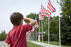 Young boy salutes flags of Memorial Day display