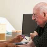 nurse injecting senior male patient